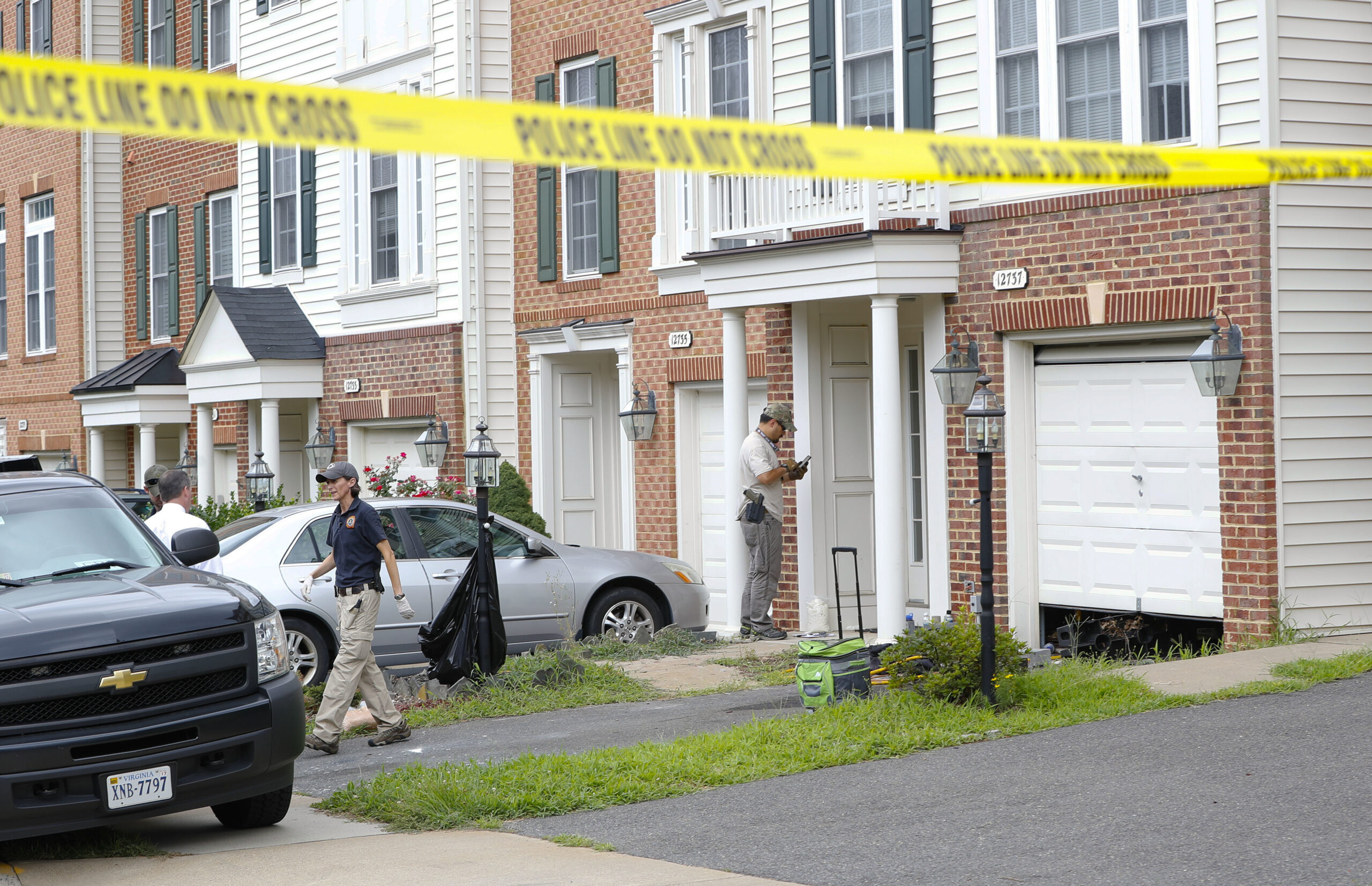 Law enforcement officers are seen outside the home of Nicholas Young, a Washington Metro Transit Officer, Wednesday, Aug. 3, 2016, in Fairfax, Va., Young was arrested at Metro's headquarters in Washington and charged with a single count of attempting to provided material support to a terrorist group. (AP Photo/Pablo Martinez Monsivais) (AP)